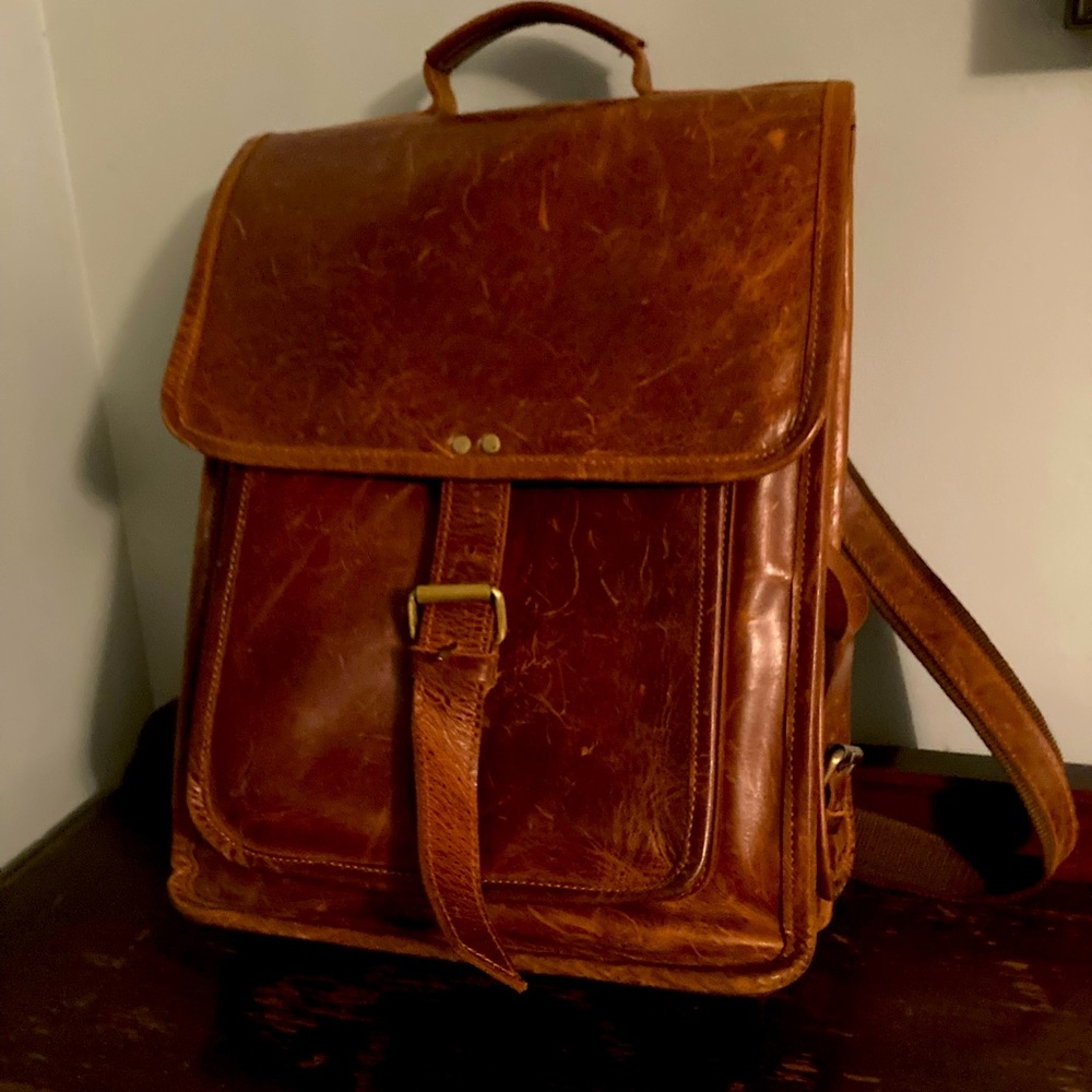 Sturdy brown leather laptop backpack with brass buckles.